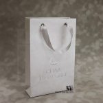 производство белых пакетов с ленточными ручками и серебряным тиснением логотипа на заказ